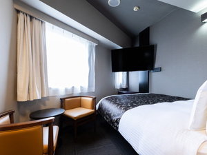 ダブルルームの客室です。テレビが壁掛けのお部屋となります。