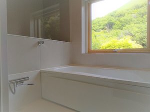 MOEGIの半露天風風呂は、北欧の大きな窓付き。さわやかな風、大室山や緑豊かな景色をお楽しみ頂けます。