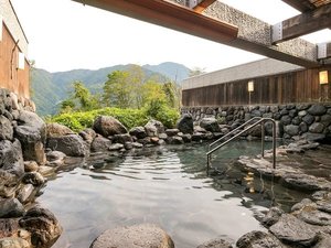 立山の山並みを望み、周囲の大自然に溶け込むような岩造りの野趣あふれる露天風呂。