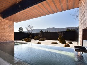 【露天風呂】2025年3月1日庭園を枯山水にリニューアル。箱根寄木細工をモチーフとした壁面が特徴的。