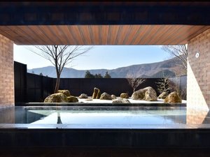 【露天風呂】2025年3月1日庭園を枯山水にリニューアル。箱根寄木細工をモチーフとした壁面が特徴的。