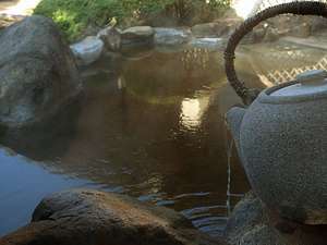 巨大な石の急須から浴槽へとお茶エキスたっぷりのお湯が注がれています。