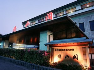 【夕暮れの雄山閣】夕暮れの空と山代温泉街の灯りに包まれる、温泉情緒あふれる雄山閣の外観。