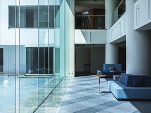 大きな窓ガラスとゆったりとしたソファのラウンジ。湖がご覧いただけます。