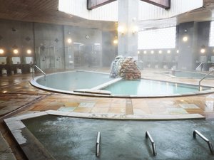 湯けむりに包まれる大浴場。登別の自然が育んだ豊かな湯が、身体の芯までやさしく温めてくれる。