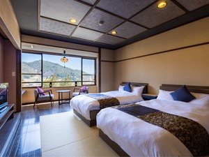 【デザイナーズベッド】窓から望む開放的な南アルプスと、シックに心安らぐ設え。