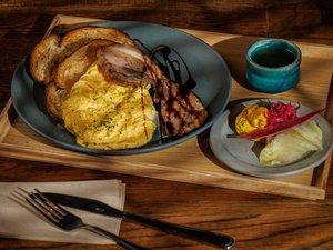 朝食メニュー例:ライ麦パンに自家製ベーコンとスクランブルエッグのポークモーニングプレート