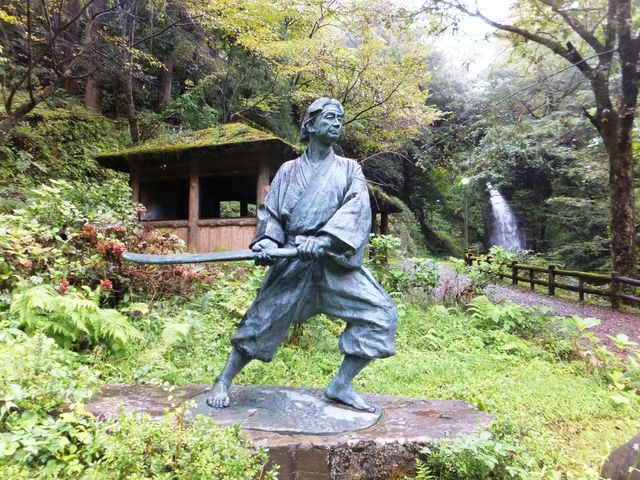 一乗滝と東屋を背景にした佐々木小次郎像_一乗滝