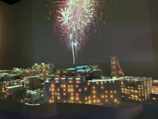 �R�͓��ׂ̗̒��m������̉ԉ΂̉f�����X�N���[���ɉf���o���Ă���̂Ŕ��͂�����܂��B_�R�͓��f�W�^���~���[�W�A��